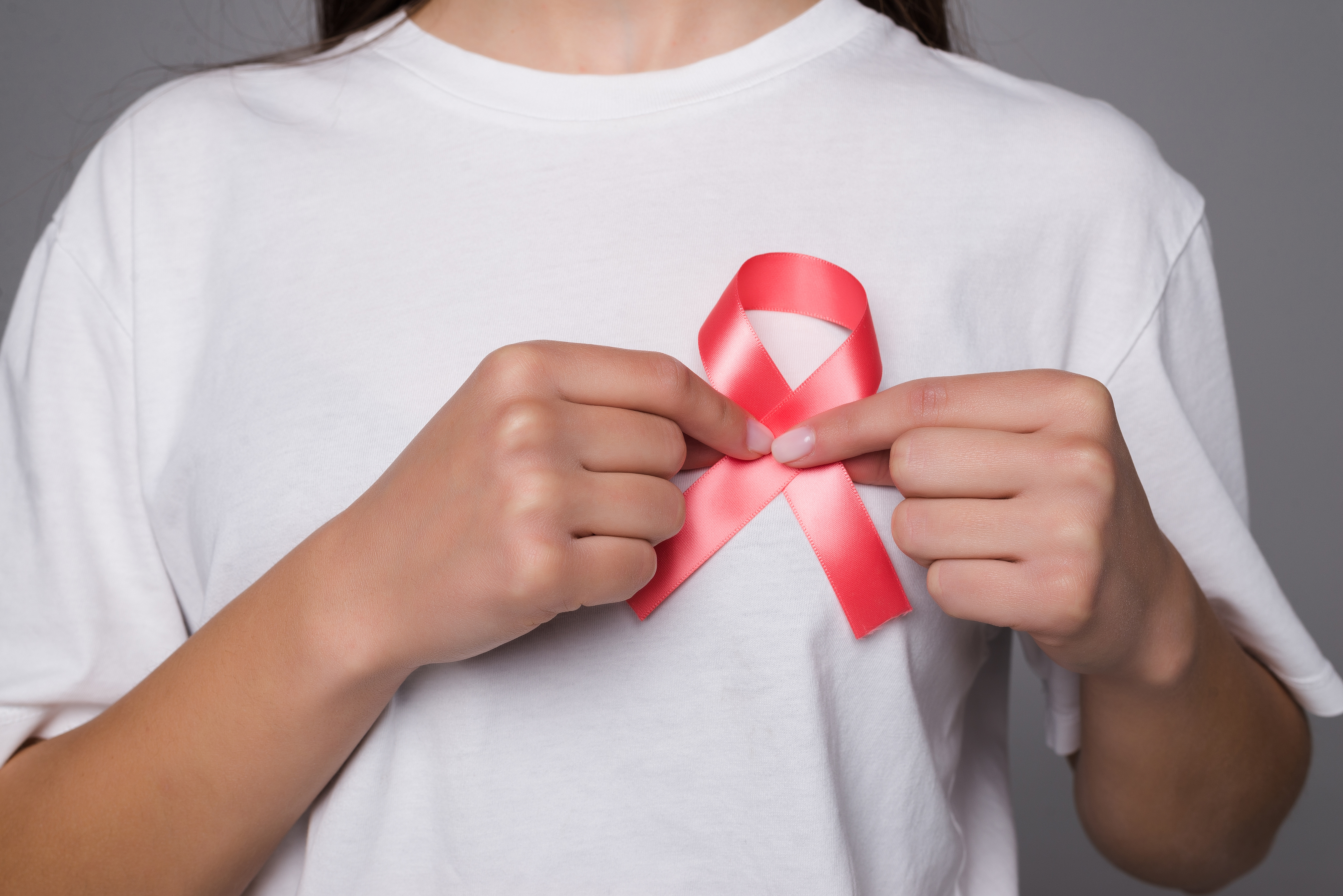 world-breast-cancer-day-concept-health-care-woman-wore-white-t-shirt-with-pink-ribbon-for-awareness-symbolic-bow-color-raising-on-people-living-with-women-s-breast-tumor-illness.jpg