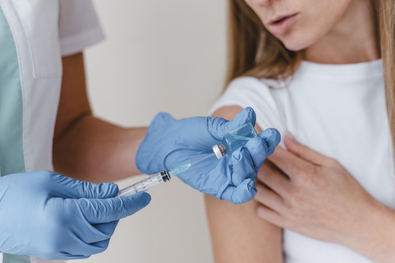 doctor-with-gloves-preparing-vaccine-for-a-woman.jpg